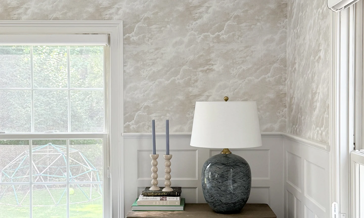 living area with a grey and white cloud wallpaper.